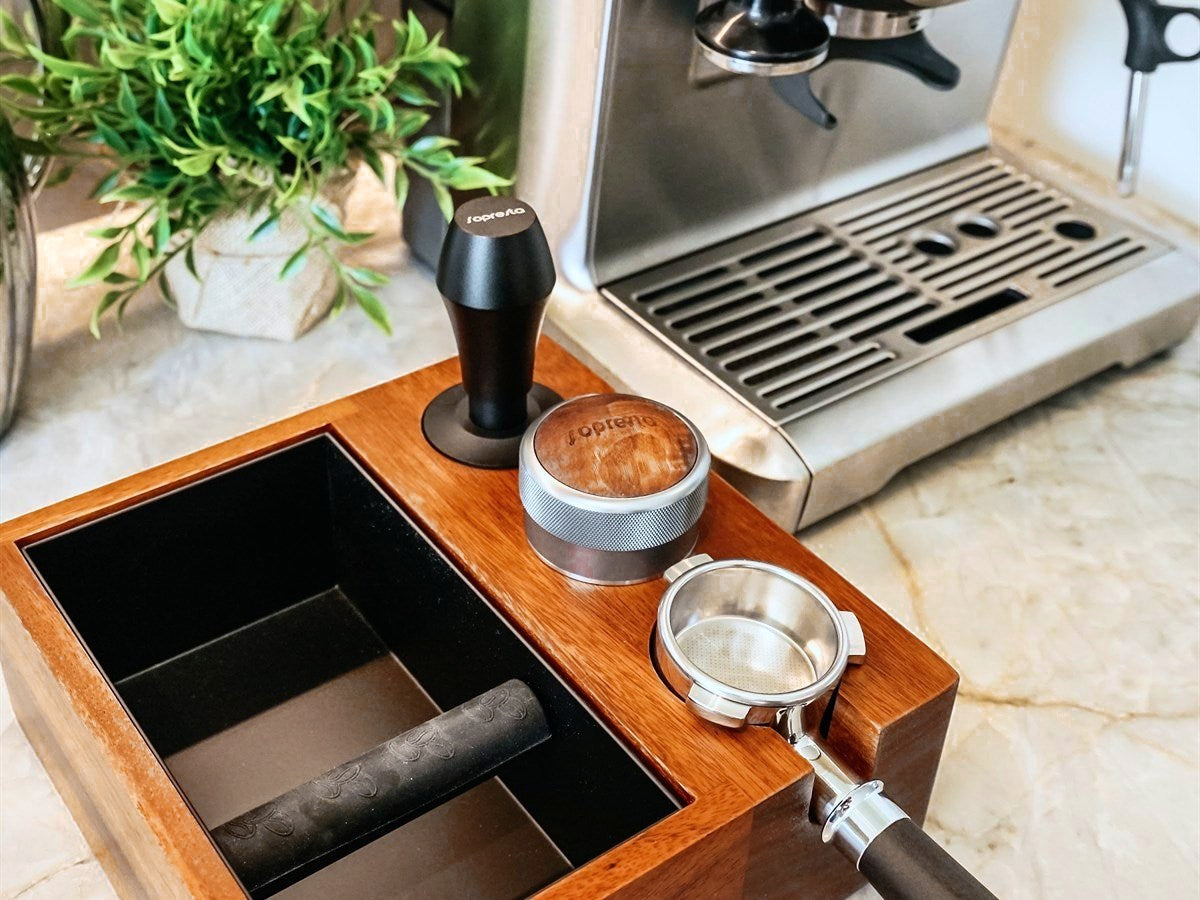 Sopresta-station i valnød med portafilter, tamper og kaffefordeler ved en Sage-espressomaskine